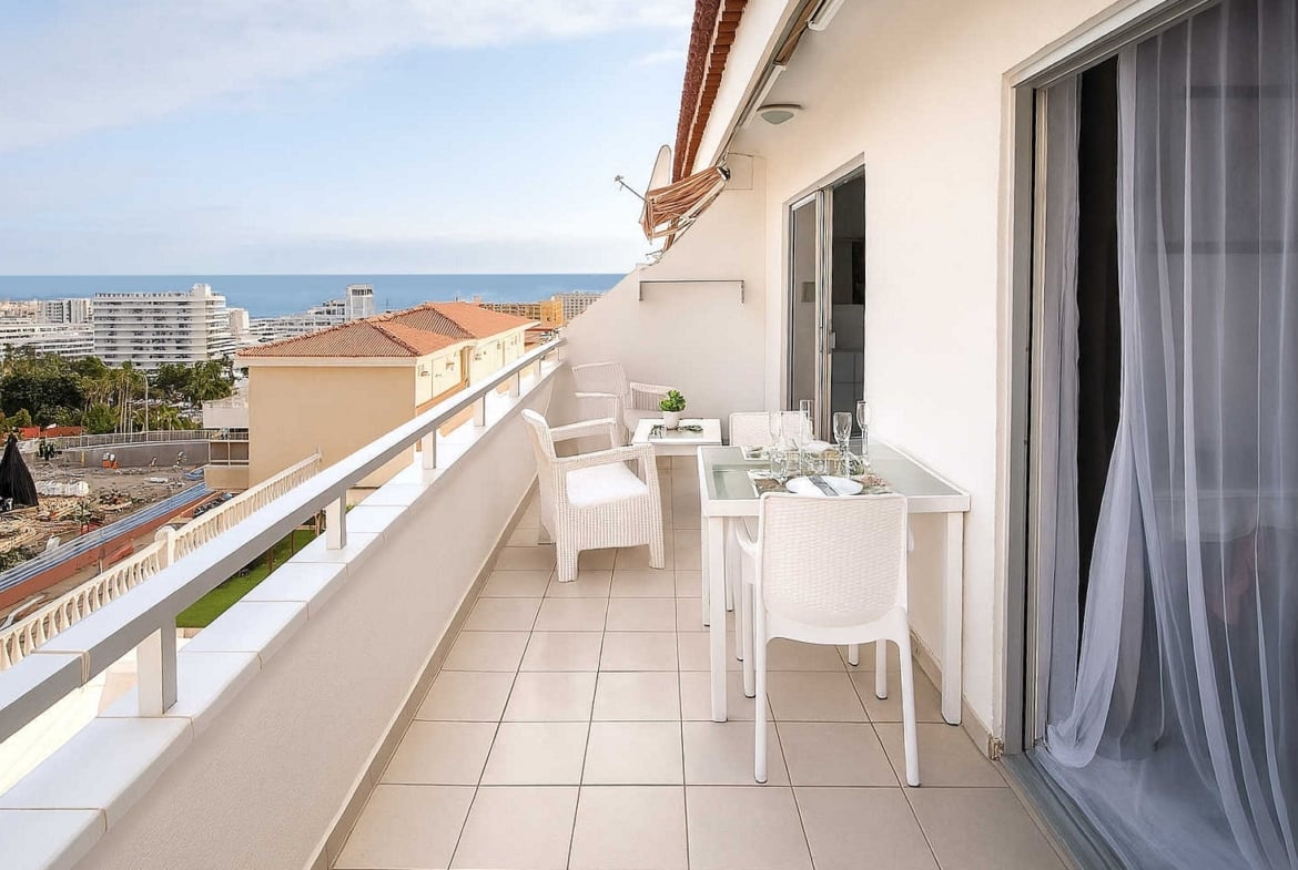 Amplio apartamento en venta en San Eugenio Alto, Tenerife, con terraza de 16 m², vistas al mar, piscina comunitaria climatizada y cerca de Playa de las Américas.