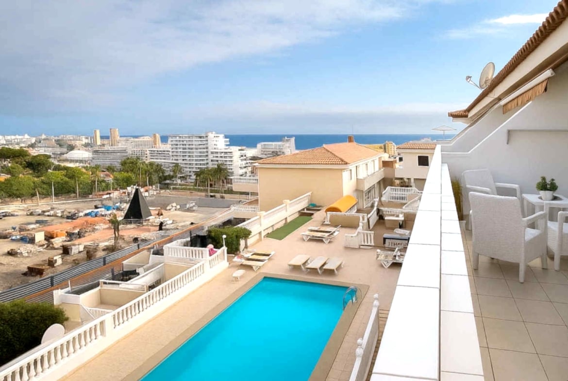 Amplio apartamento en venta en San Eugenio Alto, Tenerife, con terraza de 16 m², vistas al mar, piscina comunitaria climatizada y cerca de Playa de las Américas.
